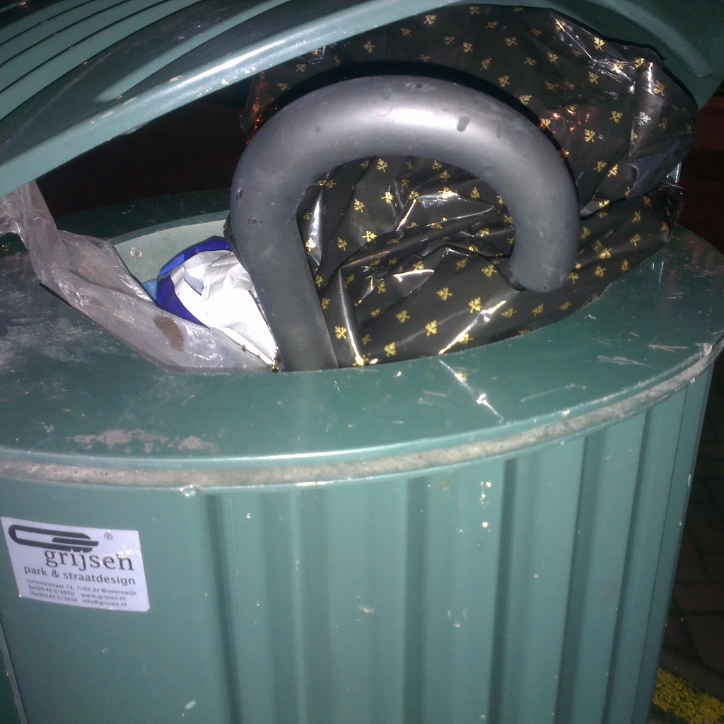 Nightly photo of a binned brolly, only the crook handle is visible