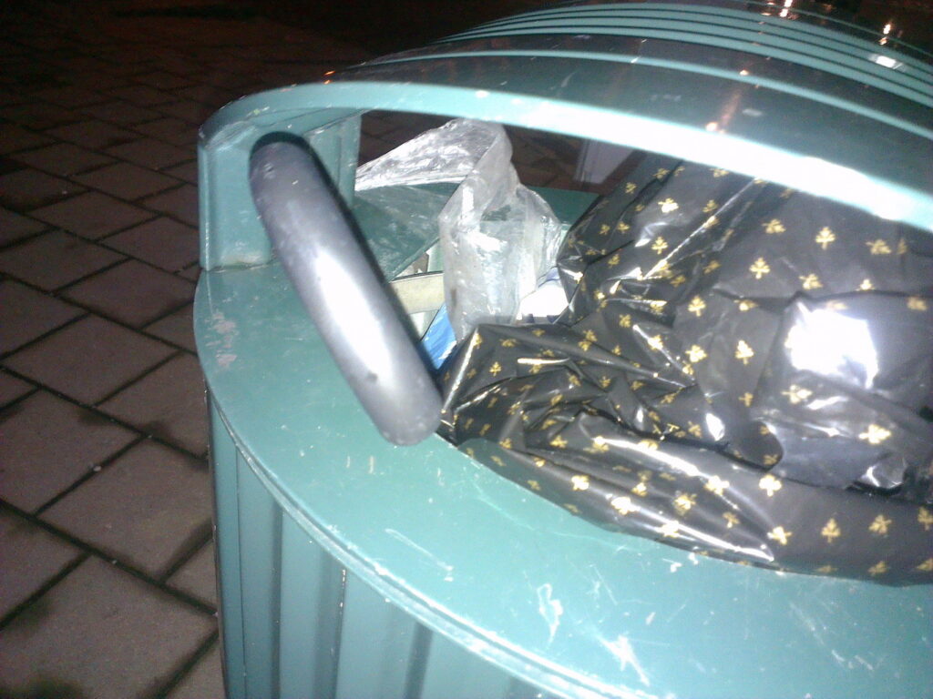 Nightly photo of a binned brolly, only the crook handle is visible
