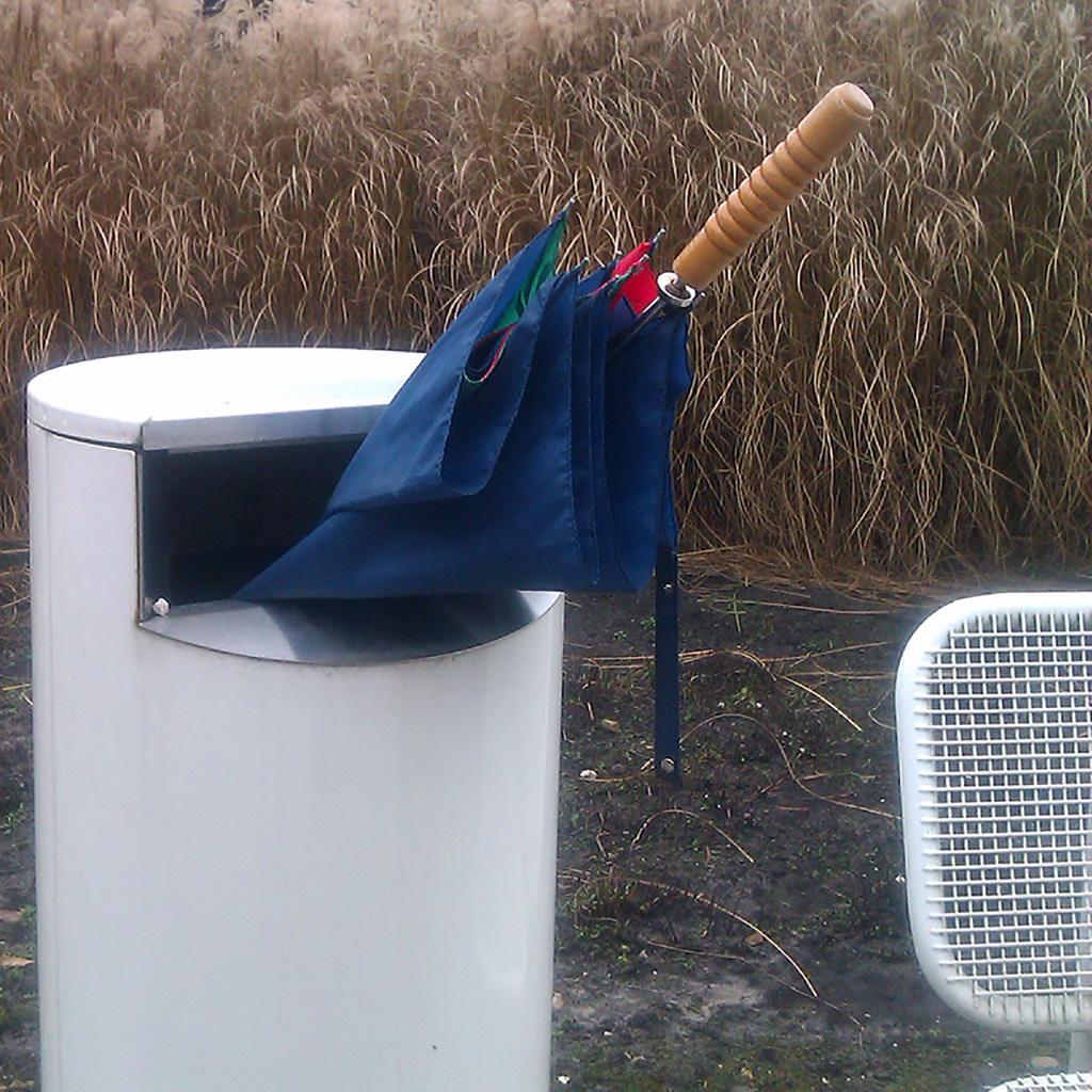 A perfect Bin Brolly, sticking out for a rather big part. White bin. Blue, red and green brolly.
